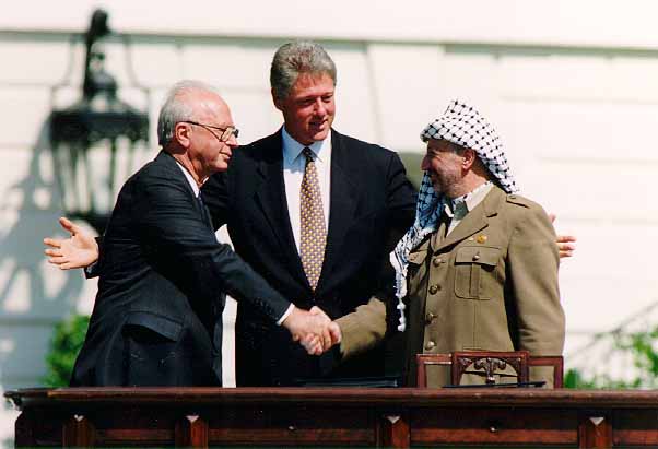 Bill Clinton stands between Yitzhak Rabin and Yasser Arafat